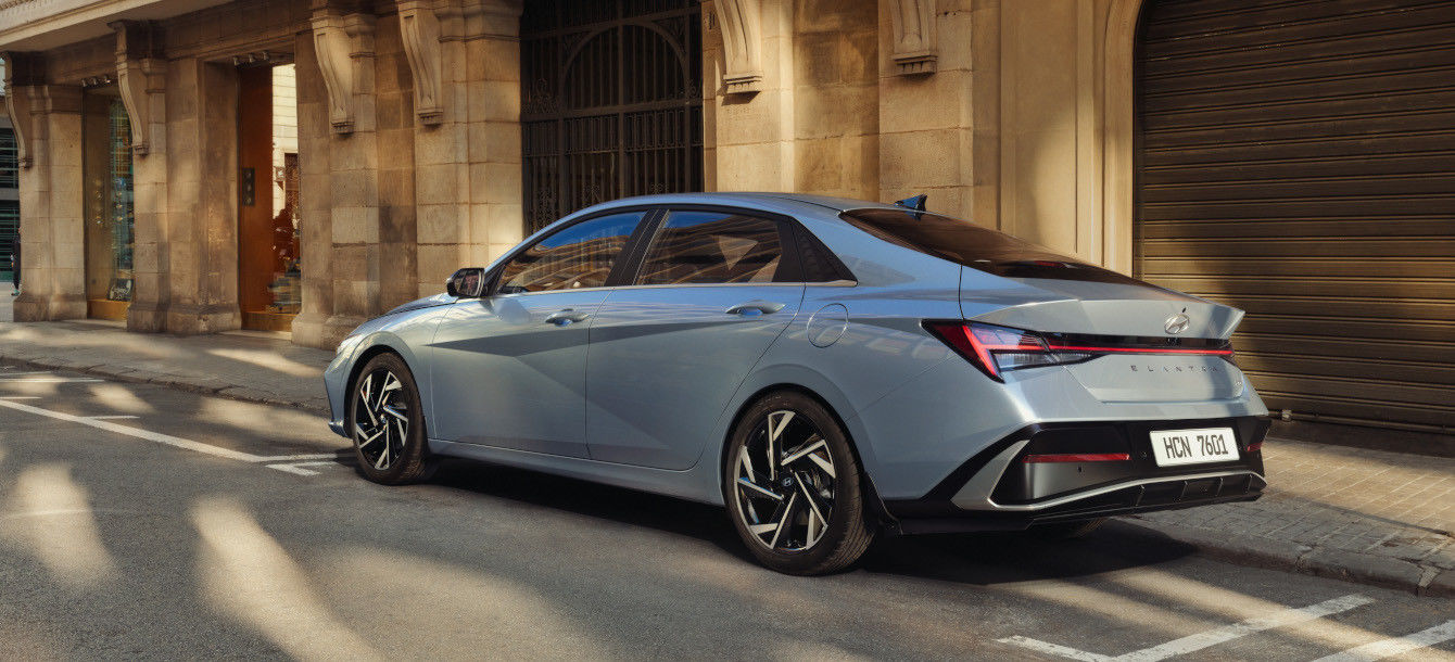 Side-front view of orange Grandi10 with lakeside view at night