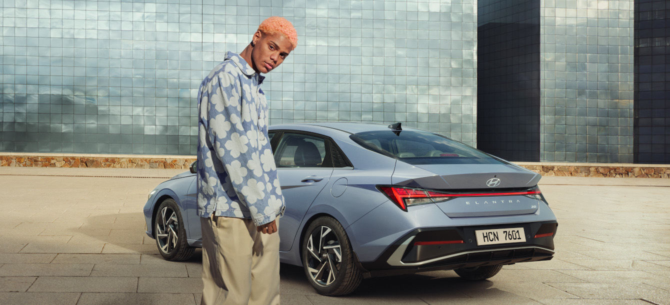 Side-front view of orange Grandi10 with lakeside view at night