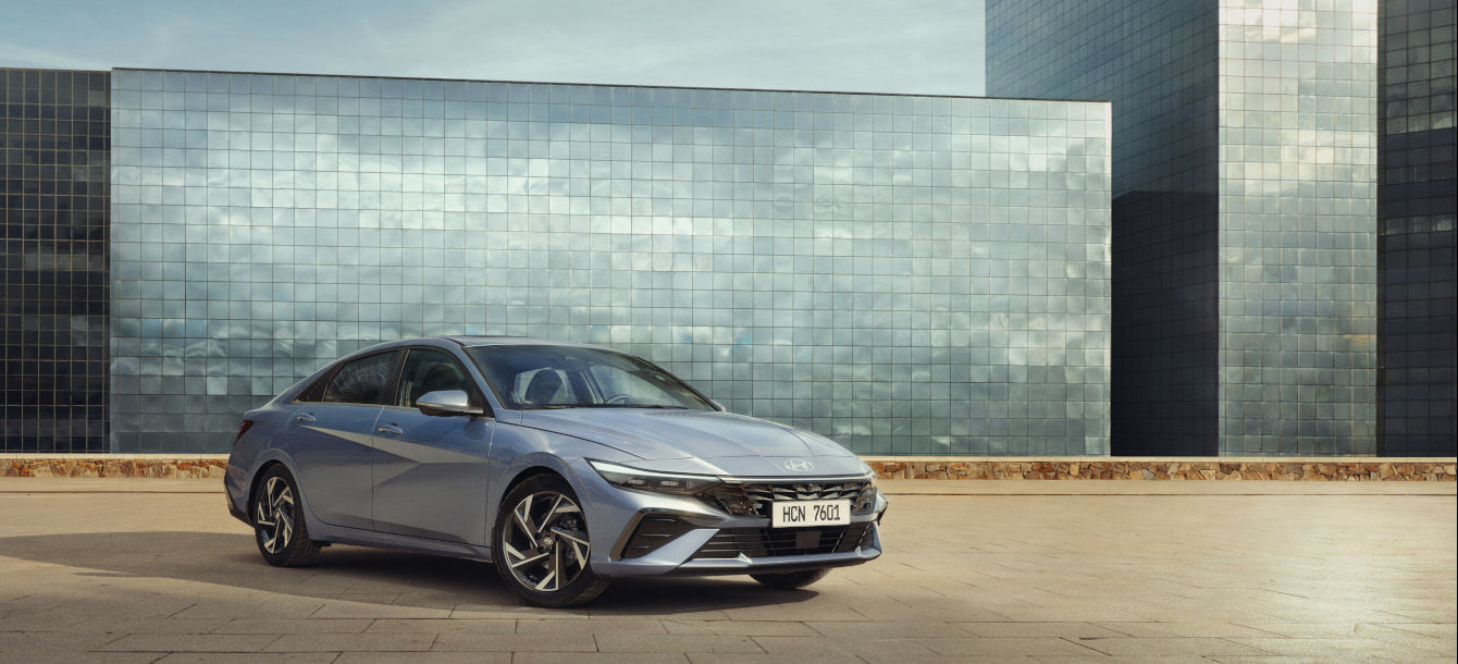 Side-front view of orange Grandi10 with lakeside view at night