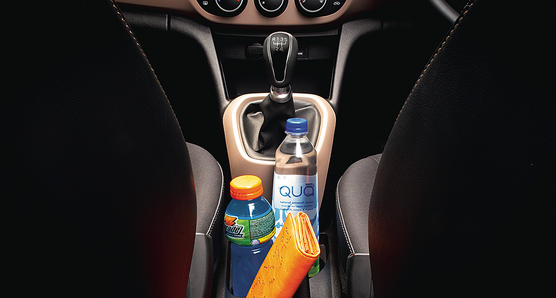 Side-front view of orange Grandi10 with lakeside view at night