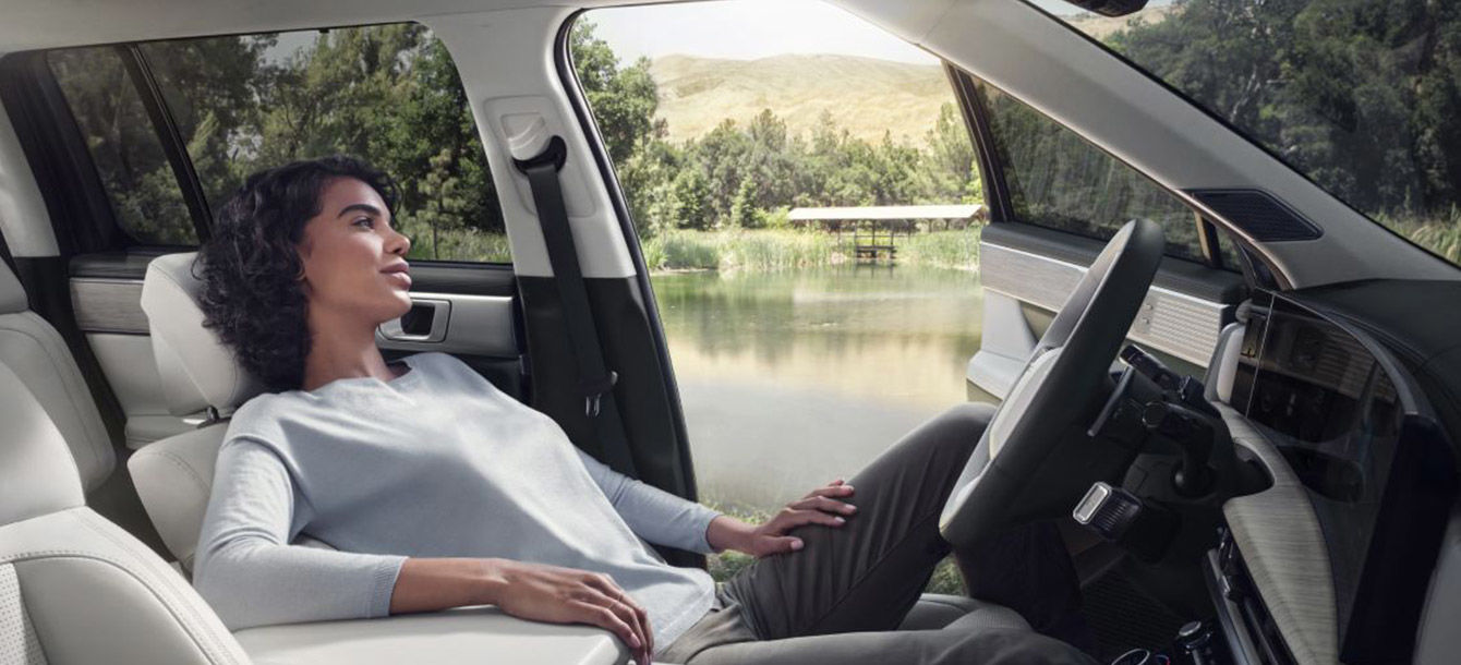 Side-front view of orange Grandi10 with lakeside view at night