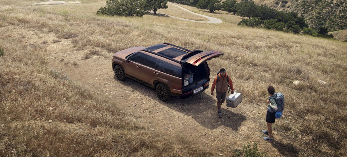 Side-front view of orange Grandi10 with lakeside view at night