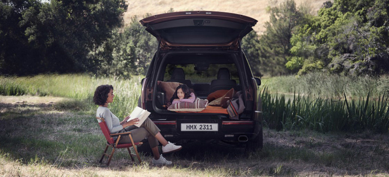 Side-front view of orange Grandi10 with lakeside view at night