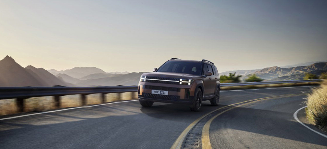 Side-front view of orange Grandi10 with lakeside view at night