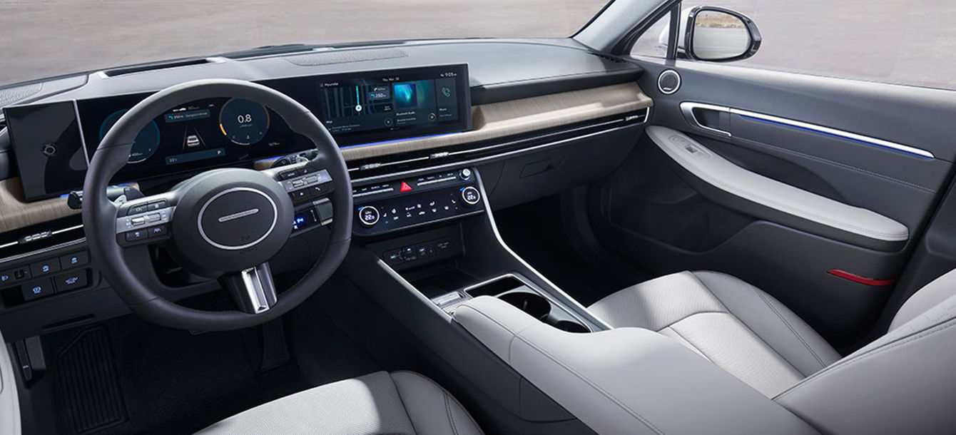 Side-front view of orange Grandi10 with lakeside view at night