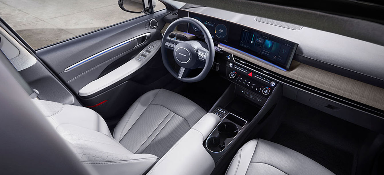 Side-front view of orange Grandi10 with lakeside view at night