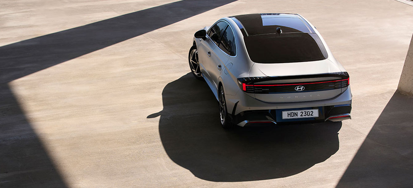 Side-front view of orange Grandi10 with lakeside view at night