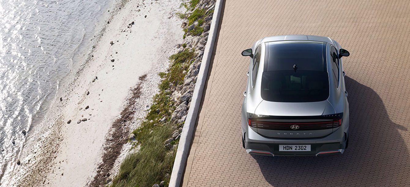 Side-front view of orange Grandi10 with lakeside view at night