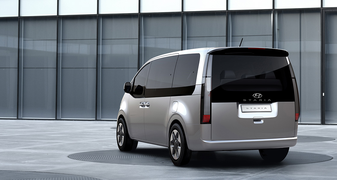 Side-front view of orange Grandi10 with lakeside view at night