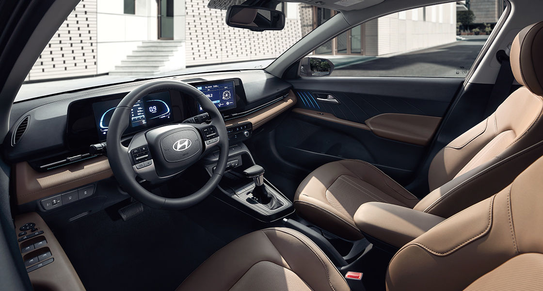 Side-front view of orange Grandi10 with lakeside view at night