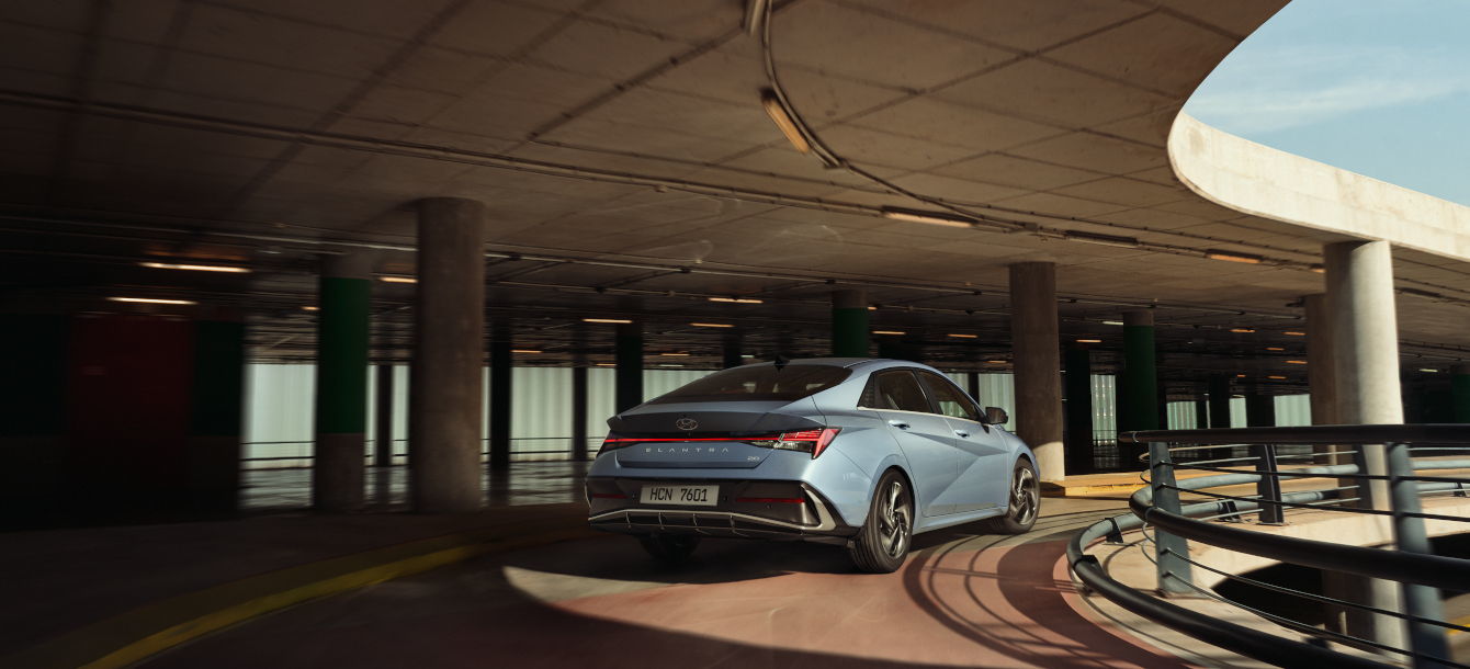 Side-front view of orange Grandi10 with lakeside view at night