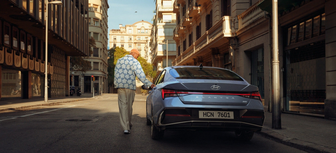 Side-front view of orange Grandi10 with lakeside view at night