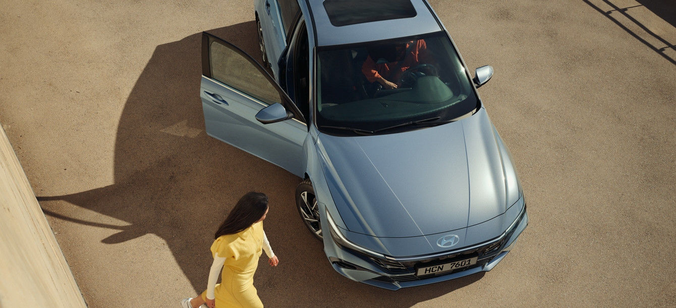 Side-front view of orange Grandi10 with lakeside view at night