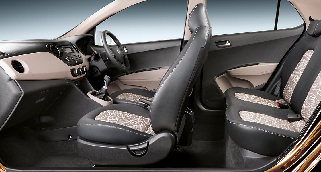 Side-front view of orange Grandi10 with lakeside view at night