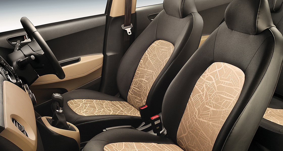 Side-front view of orange Grandi10 with lakeside view at night