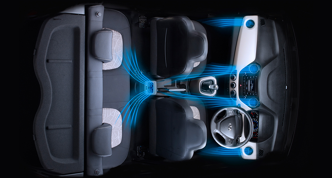 Side-front view of orange Grandi10 with lakeside view at night