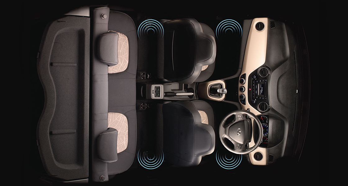 Side-front view of orange Grandi10 with lakeside view at night