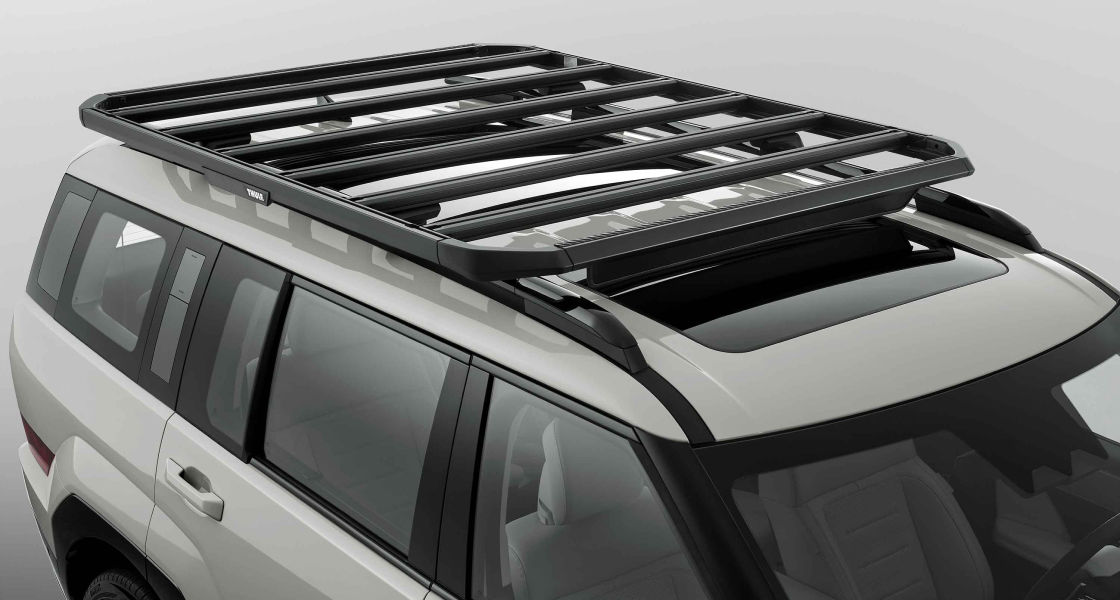 Side-front view of orange Grandi10 with lakeside view at night