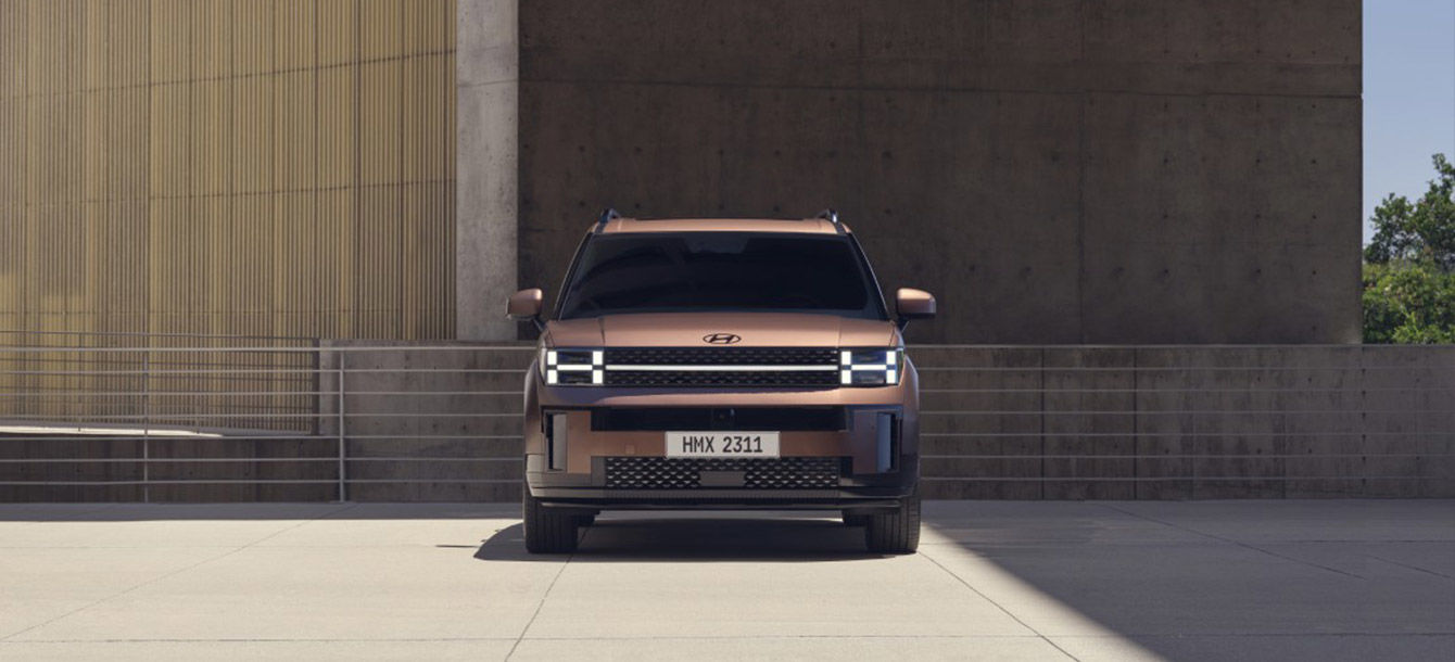 Side-front view of orange Grandi10 with lakeside view at night