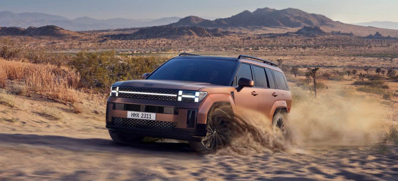 Side-front view of orange Grandi10 with lakeside view at night