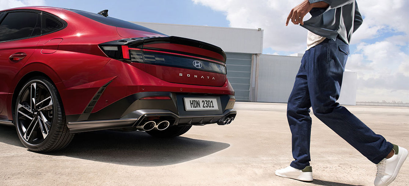 Side-front view of orange Grandi10 with lakeside view at night