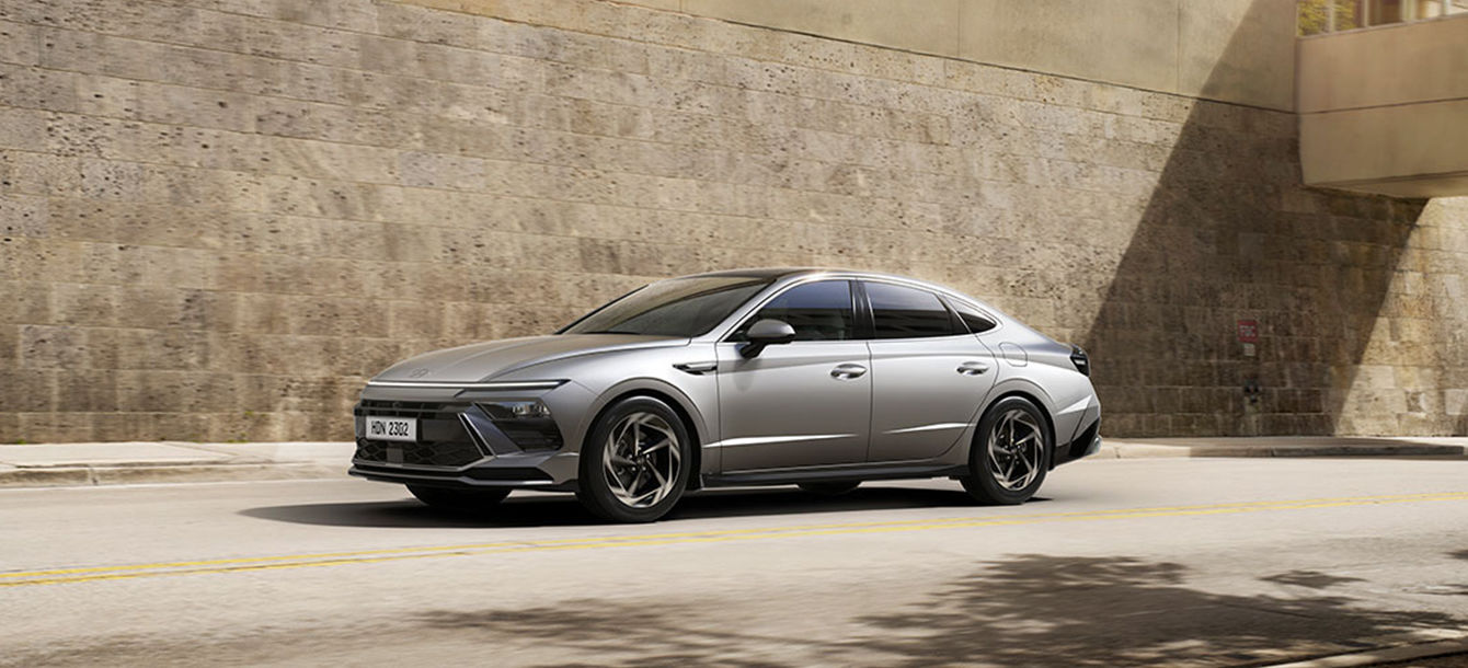 Side-front view of orange Grandi10 with lakeside view at night
