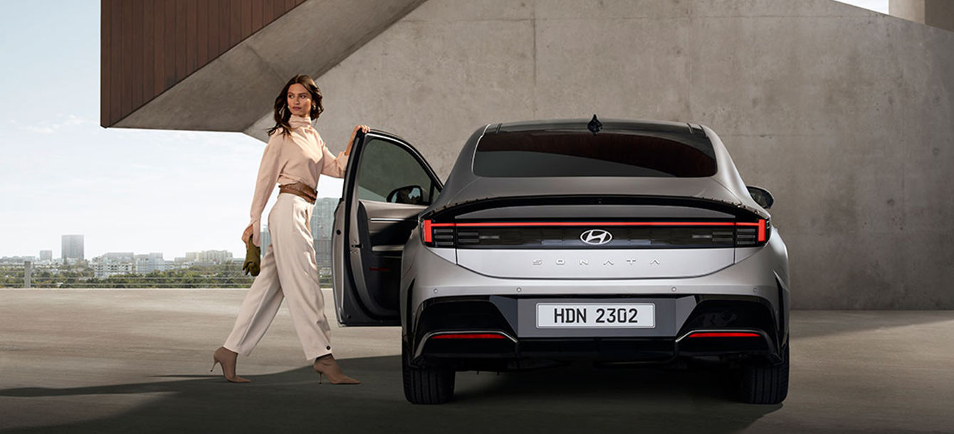 Side-front view of orange Grandi10 with lakeside view at night